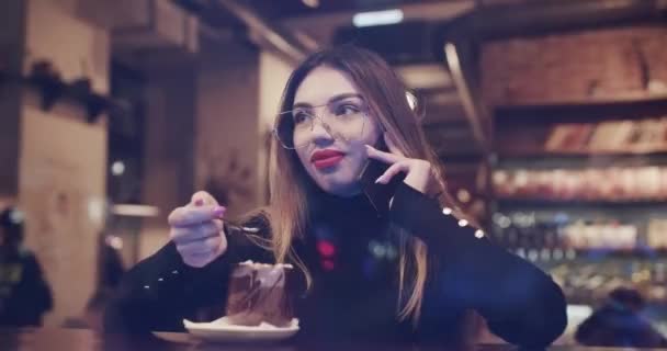 Kafede akıllı telefon kullanan güzel bir genç kız sosyal medyada mesajlar paylaşıyor kahve dükkanında mobil teknolojinin keyfini çıkarıyor. — Stok video