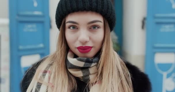 Jovem encantadora com um cabelo magnífico, grandes olhos azuis, batom vermelho e aparência elegante. Jovem atraente se vira para câmera e sorri . — Vídeo de Stock