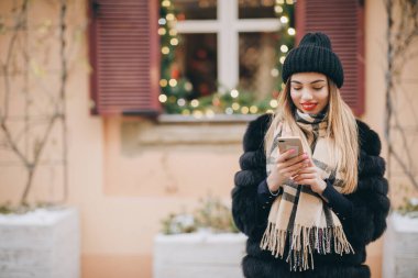 Kadın akıllı telefon içeriğini kontrol ediyor. Akıllı telefon mesajları kullanan güzel bir genç kız sosyal medyada mesajlarını paylaşıyor ve mobil teknolojiden keyif alıyor.