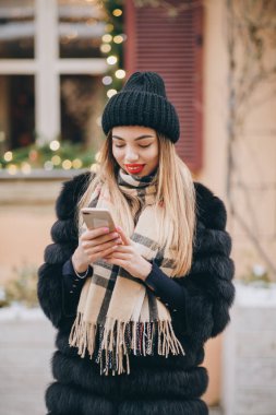 Yaşam sevinci, aktif yaşam tarzı, moda blogcusu, podyum. Akıllı telefon kullanan ve aboneleri için video blogu kaydeden çekici güzel kadın blogcu