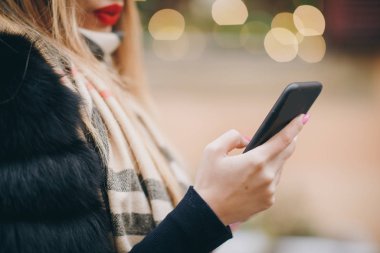 Akıllı telefon kullanan ve aboneleri için video blogu kaydeden çekici bir kadın blogcu. Yaşam sevinci, aktif yaşam tarzı, moda blogcusu, podyum.