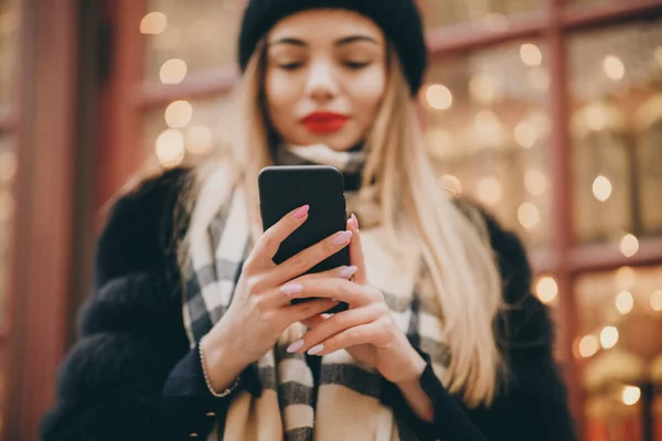 Jonge vrouw draagt hoofddoek lopen in het centrum van de stad, met behulp van smartphone. Communicatie, online winkelen, sociaal netwerkconcept. — Stockfoto