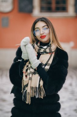 Kamerada poz veren neşeli kız. Dışarıdaki kameraya gülümseyen kadın yüzünün portresi. Sarışın kadını kapatın, şehir planında mutlu hissedin. Gülen kadın portresi