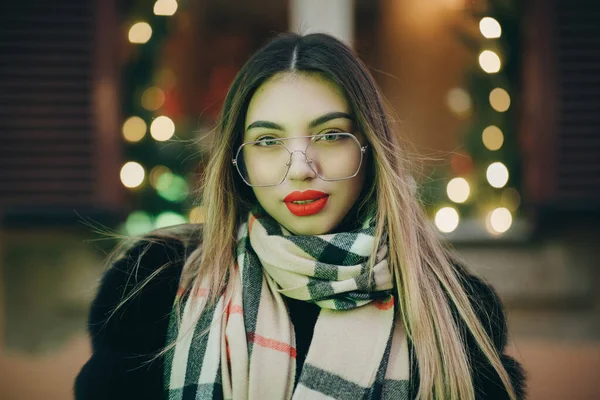 Kobieta w okularach patrzeć na aparat pozuje w centrum miasta Piękne włosy atrakcyjny uśmiech dziewczyny. Zamknij strzał Kobieta w okularach w czasie zimy. Koncepcja technologii, zimy i wakacji — Zdjęcie stockowe