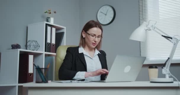 Lycklig kvinna som använder bärbar dator för internetbank, ler betala räkningen med online-program på bärbar dator som arbetar på datorn — Stockvideo