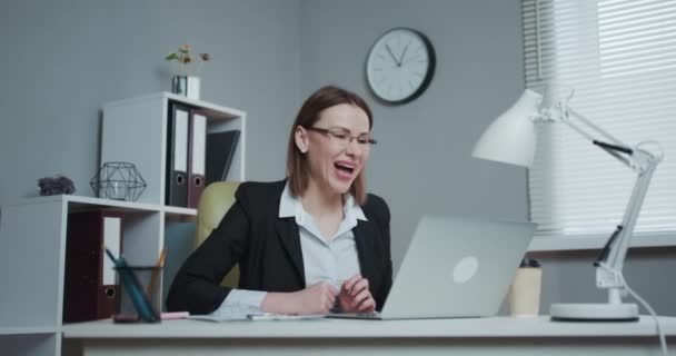 Smiling Young Woman Wearing Eyeglasses is Writing on her Laptop Computer — Stock Video