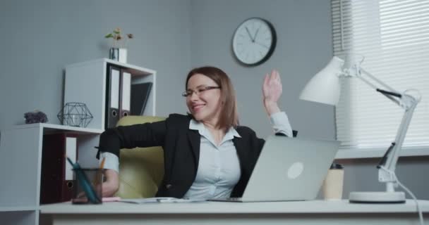 Retrato de la hermosa empresaria bailando sentada en su escritorio. Mujer exitosa y feliz celebrando ventas récord. — Vídeo de stock