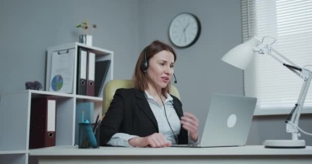 Lycklig kvinna i hörlurar talar via webbkamera på webinar utbildning titta på bärbar dator, affärskvinna talar genom videokonferens samtal, online lärare undervisning konsultera klient e-coaching koncept — Stockvideo