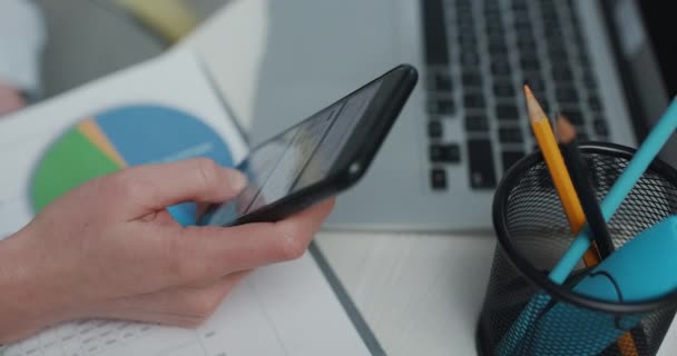 Las manos de la mujer navegando por Internet usando un teléfono inteligente, se desplaza a través de sus noticias. Chica usando la aplicación de teléfono móvil y mensajería — Vídeos de Stock