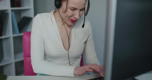 Woman customer care support service agent call center operator in wireless headset talk consult online client using computer solving complaints on helpline or sell services in telesales office — 비디오