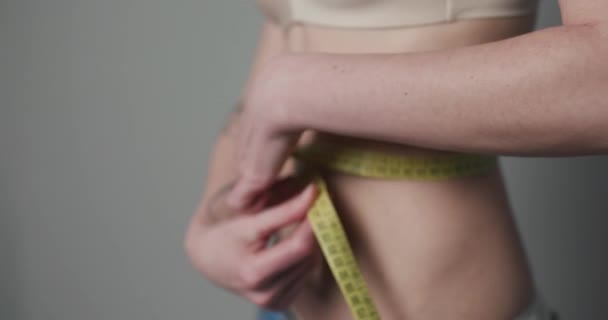 Женщина, контролирующая свои меры с помощью ленты. Женщина измеряет свое тело. Концепции потери веса . — стоковое видео