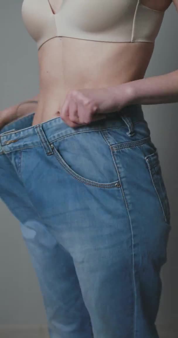 Woman Losing Weight After Diet, Slim Down, Burning Fat and Flat Waist. Thin Girl Show Weight Loss and Old Big Jeans. Skinny Female Belly Wearing Too Large Pants. — Stock Video