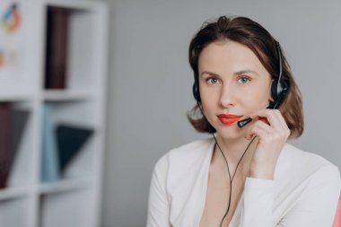Beautiful Women Call Center Wear Headset and Working with Computer while Consulting Customer with Online Problem. Support and Operator Service Business Representative Concept. Online marketing. clipart