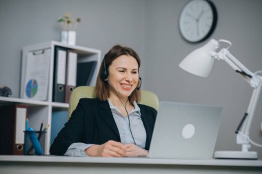 Webinar eğitiminde web kamerasıyla konuşan kulaklıklı mutlu kadın dizüstü bilgisayara, video konferans görüşmesiyle konuşan iş kadınına, internet öğretmenine danışmanlık konsepti öğreten müşteriye bak..
