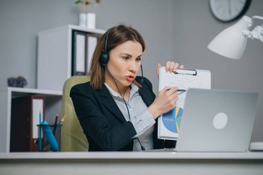 Mali rapor webcam konuşma yapmak Haritayı istatistikleri konuşmak video çağrısı ofis, iş coach kameraya bakarak açıklamak için istemci, eğitim online pazarlama stratejisi kağıt tutan işkadını.