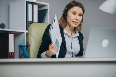 Webinar eğitiminde web kamerasıyla konuşan kulaklıklı bir iş kadını dizüstü bilgisayara, video konferans görüşmesiyle konuşan bir iş kadını, müşterilere e-koçluk öğreten online öğretmenlik konsepti.