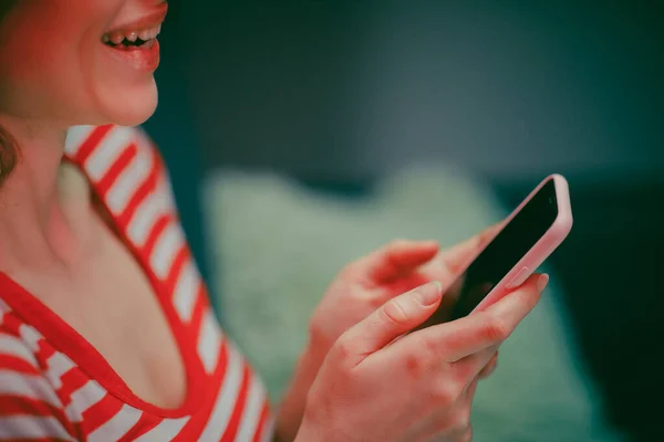 Kobieta Holding Smart Phone Patrząc na ekran telefonu komórkowego śmiejąc Korzystanie Korzystanie z aplikacji mobilnych na zakupy. Zabawa Gry Grając na czacie w mediach społecznościowych Usiądź na kanapie w domu. — Zdjęcie stockowe
