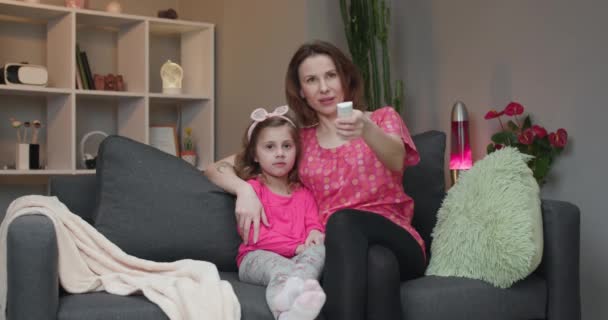 Mulher com sua filha olhando para a TV e rindo . — Vídeo de Stock