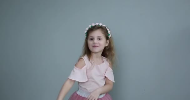 En liten flicka med bukett tulpaner. Flicka hålla en gul tulpan i handen på en grå bakgrund — Stockvideo