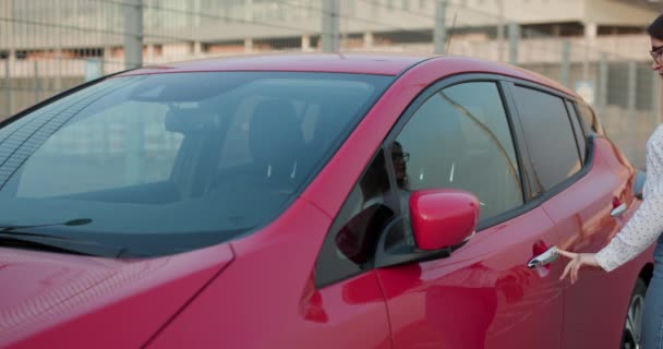 Mulher atraente usando tecnologia moderna para desbloquear as portas do carro. Mulher a abrir a porta e a entrar no carro. Uma menina abre o carro e senta-se dentro — Vídeo de Stock