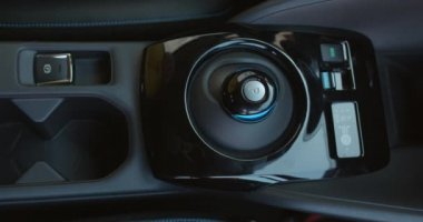 Kadın el sıkışarak vites düğmesine basıyor. Parmaklar düğmeye bassın ya da tersine çevirsin.