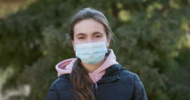 Salgın sırasında koruyucu takan hasta bir kız. Güzel beyaz kız dışarıda tıbbi maske takıyor. Coronavirus COVID-19 salgını sırasında tıbbi maske takan kız.