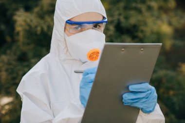 Doktor epidemiyoloji uzmanı Coronavirus COVID-19 ile savaşıyor. Virolog beyaz bir eldiven içinde boş bir kağıt üzerinde bir kalem tutuyor.