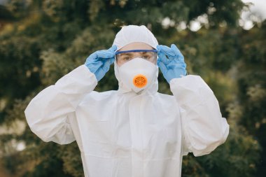 Coronavirus COVID-19 ile savaşan doktor epidemiyolojistin portresi. Virolog tarafından korunanlar. Maskeli, eldivenli, gözlüklü beyaz tıbbi elbise. Salgın sırasında küresel krizin yüzü