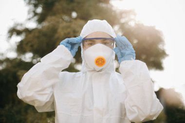Coronavirus COVID-19 ile savaşan doktor epidemiyolojistin portresi. Virolog tarafından korunanlar. Maskeli, eldivenli, gözlüklü beyaz tıbbi elbise. Salgın sırasında küresel krizin yüzü.