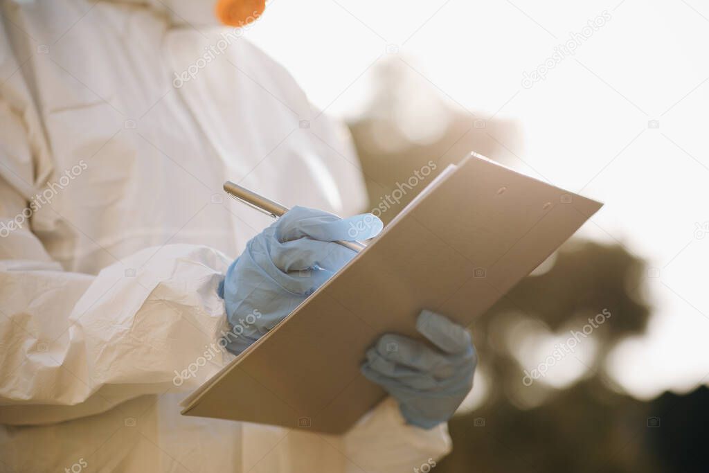The Virologist hand in a white glove holds a pen on a blank sheet of paper. The doctor holding clipboard with blank paper in the hand