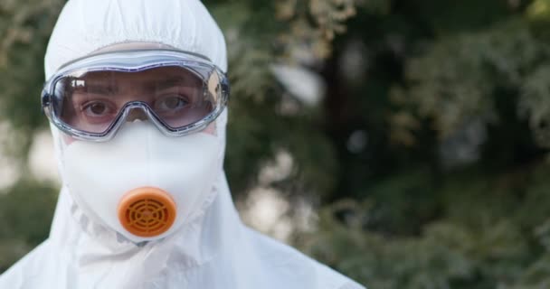 Virologista trabajador en traje protector, gafas y respirador. Covid-19 coronavirus epidemia propagación prevención, EE.UU., Italia, Europa — Vídeo de stock