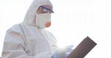 Yüz maskesi takan kadın bir virolog doktor ve takım elbiseli dışarıda duruyor ve verileri not ediyor. Coronavirus COVID-19 salgını. Koruyucu Maskeli Müslüman Kadın.