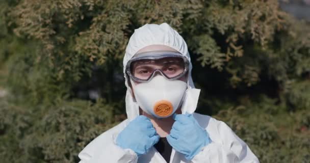 Портрет епідеміолога, що захищає пацієнтів від коронавірусу COVID-19 в масці. Глобальна пандемія, Європа, Італія, США. Лікар-віролог працює в костюмі, окуляри. — стокове відео