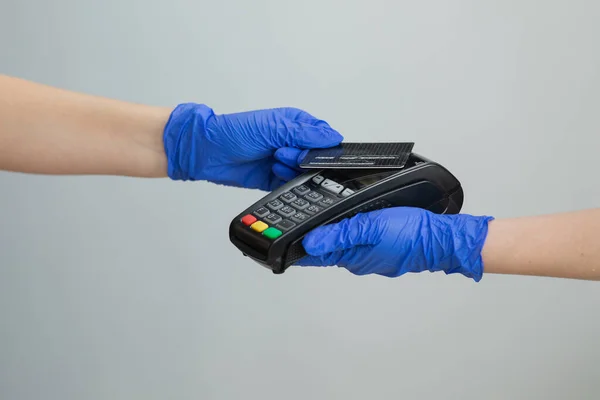 Banking services of electronic money. Financial success and safety. Credit card machine for money transaction. Woman hand in gloves with credit card swipe through pos terminal and enter pin code.