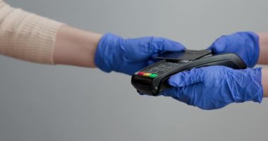 Eldivenli bir kadın postal terminalinden geçer ve şifre girerdi. Elektronik paranın banka hizmetleri. Finansal başarı ve güvenlik. Para aktarımı için kredi kartı makinesi.