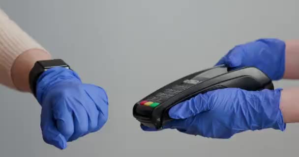 Les femmes déposent des gants en utilisant smartwatch pour acheter des produits au terminal de point de vente dans un magasin de détail avec technologie de paiement d'identification nfc utilisée pour la vérification . — Video