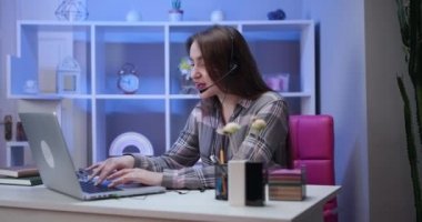 Video konferans görüşmesiyle konuşan kız öğrenci, online öğretmen danışman müşteri e-koçluğu konsepti. Webinar eğitiminde web kamerasıyla konuşan kulaklıklı mutlu kız dizüstü bilgisayarına bak ve not al..