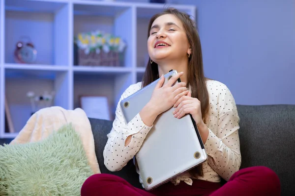 Brunette woman hug laptop computer, she love her work. Happy young girl,student hugging book, notebook, love studying, reading, finished homework. Sitting in her room at table with laptop — Stock Photo, Image