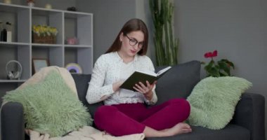 Kitap okuyan genç bir öğrenci. Evdeki yatakta kitap okuyan güzel, genç esmer kadın.