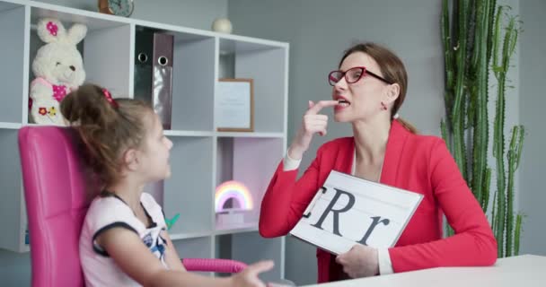 Logopädin bringt den Mädchen bei, den Buchstaben R zu sagen. Sprachtherapeutin bringt dem Vorschulkind die Aussprache bei. Sprachfähigkeitsproblem Sprachunterricht Konzept. — Stockvideo