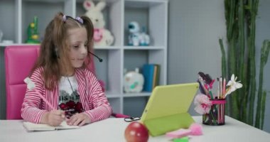 Çevrimiçi uzaklık öğrenimi, evdeki web kamerasıyla arkadaşınla iletişim kurmak. E-öğrenme ve kendini izole etme. Genç kız tablet internet konferans uygulamasında güzel bayan öğretmenle konuşuyor..