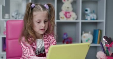 Evde internette sörf yapan küçük bir çocuk. Çocuklar teknoloji bağımlılığı konsepti. Dijital tablet teknolojisi kullanan ilginç anaokulu öğrencisi kız..