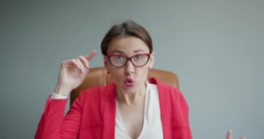 Gergin iş kadını blogger vlogger etkileyicisi evde oturup kamera karşısında konuşuyor ve görüntülü sohbet ediyor. Konferans çağrısı kayıt yaşam tarzı vlog 'u