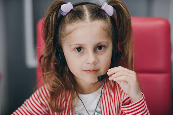 Een schattig meisje met een koptelefoon. Kleutermeisje of kind luisteren naar muziek geïsoleerd op grijze achtergrond. Melodie-, klank- en muziekconcept — Stockfoto