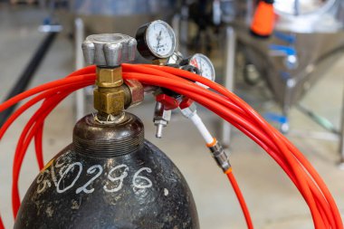 Bira fabrikasının içindeki bira ekipmanları. Kapılar, borular ve musluklar. Erkek eli pipo tutar..