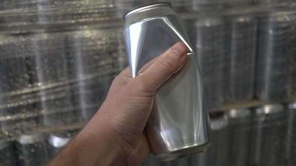 男性の手はビールタンクを背景にアルミ缶を絞る 醸造所の中だ ゆっくり — ストック動画