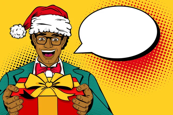 Wow, uomo della pop art natalizia. Uomo africano in cappello, vestito e occhiali di Babbo Natale con scatola regalo sorridente e bolla vocale vuota. Illustrazione vettoriale in stile comico retrò. Invito per il nuovo anno . — Vettoriale Stock