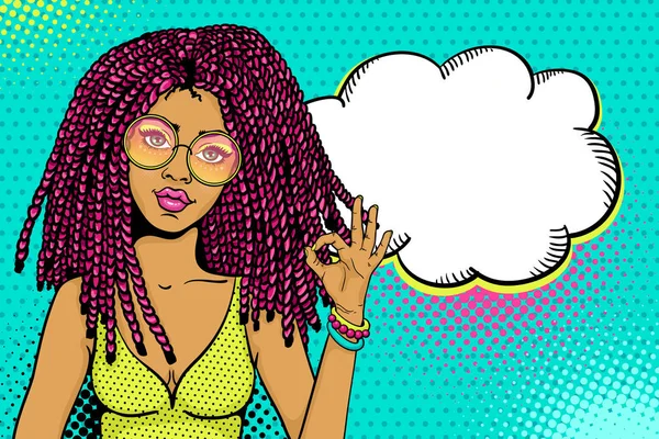 Pop art female face. Sexy african american hippie woman with pink dreadlocks in round glasses shows okay sign and empty speech bubble. Vector colorful background in pop art retro comic style. — Stock Vector
