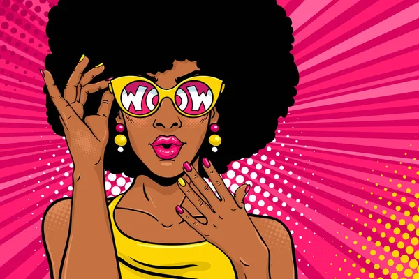 Cara de arte pop Wow. Sexy mujer negra sorprendida con el pelo africano y la boca abierta sosteniendo gafas de sol en su mano con la inscripción wow en reflexión. Vector fondo brillante en el estilo retro cómic arte pop . — Vector de stock