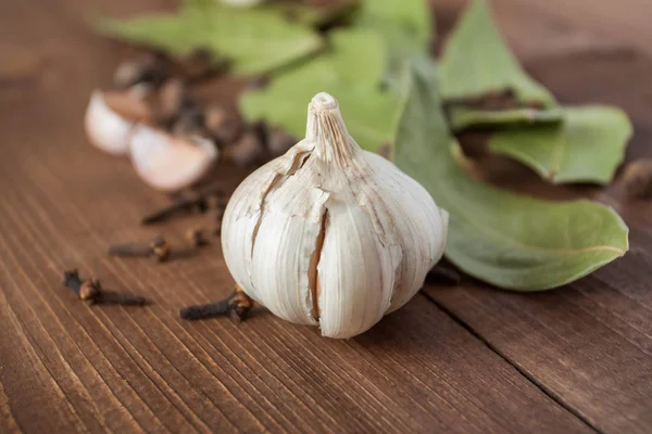 Gewürze und Knoblauch auf einem Holztisch. — Stockfoto